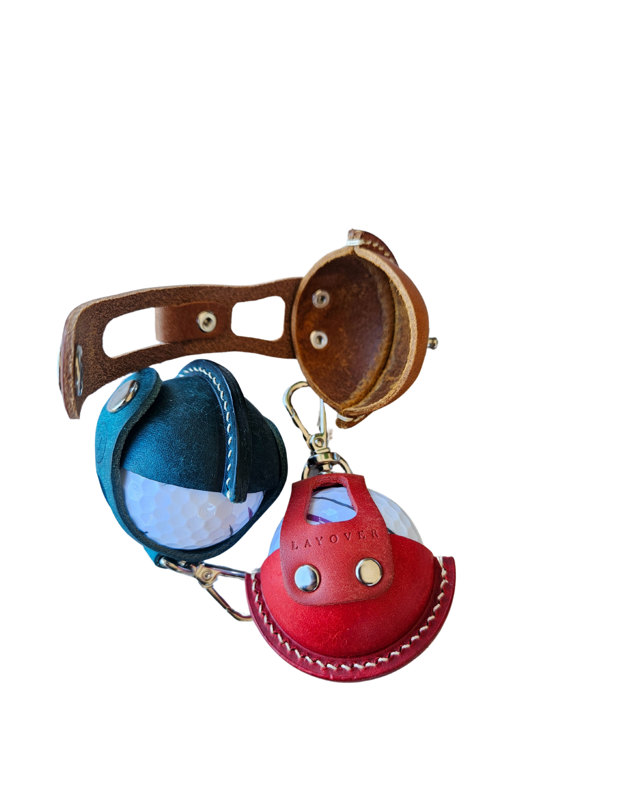 Three leather golf ball holders in green, red, and brown, each holding a golf ball. The holders feature a smooth leather finish, precise stitching, and a compact design, arranged side by side to showcase their vibrant colors and craftsmanship