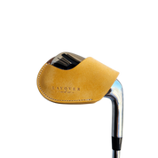 Studio shot of leather magnetic golf iron covers in yellow neatly arranged to showcase their smooth texture, precise stitching, and minimalist design under soft lighting.